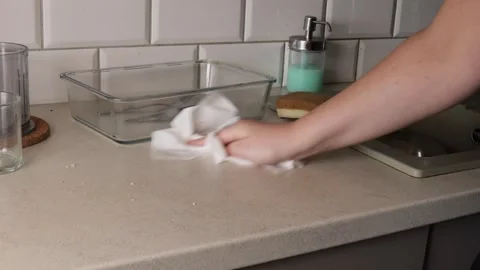 Hand cleaning a smooth kitchen countertop with a soft cloth, removing dust .. Stock Footage 320737737