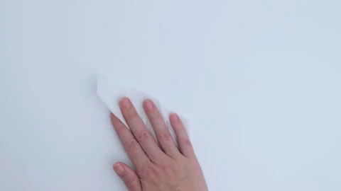 Hand is cleaning a smooth white surface with a cloth, showcasing the act of Stock Footage 312307241