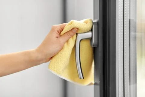 Hand cleaning window handle with microfiber rag Photos