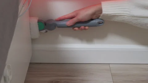 Hand Cleans Tight Baseboard Corner with Specialized Roller Tool. Stock Footage 321151109