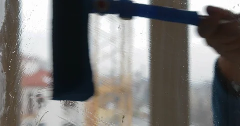 Hand cleans the wiper with a dirty window from the outside Stock Footage 103356377