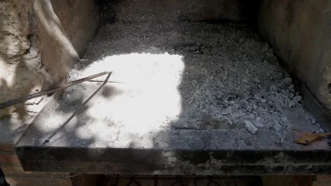 Hand Clearing Ashes From Outdoor Barbecue Grill With Metal Tool In Sunlight Stock Footage 336526659