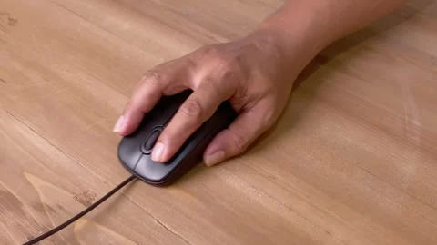 Hand clicking and dragging on computer mouse on table Stock Footage 345586436