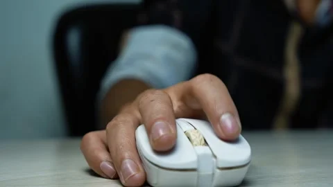 Hand clicking a computer mouse at a desk, Close-up of a hand using a white .. Vídeo Stock 345119496