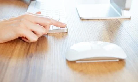 Hand clicking computer mouse at office wooden desk by white smartphone layout 写真素材