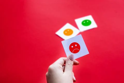 Hand of client show a feedback card with bad smile face. Service rating, sati Stock Photos