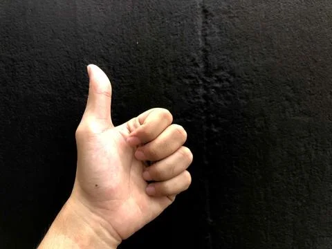 Hand of client show thumb up isolated on black background Stock Photos