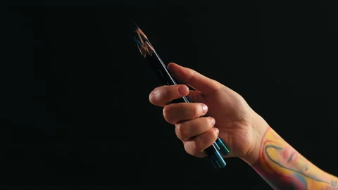 A hand in close-up on a black background holds pencils Stock Footage 184037833