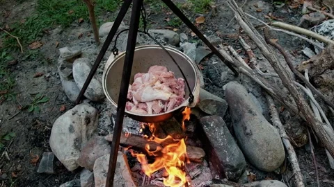 Hand closes lid of the cauldron, cauldron in which food is cooked, which hangs o Stock Footage 175682186
