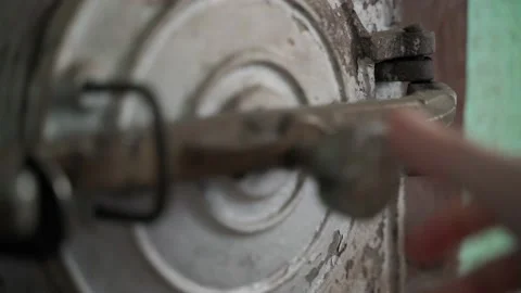 A hand closes the round door of an old rural stove with a burning fire. Wood Stock Footage 217441293