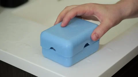 Hand closing a blue plastic soap dish Stock Footage 329199810