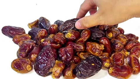Hand Collecting Dried Dates to Place Back into Container on Dark Background Video stock 328136858