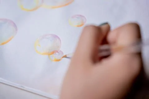 Hand coloring bubble drawing with colored watercolors in a sketchbook Stock Photos