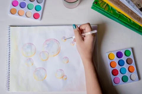 Hand coloring bubble drawing with colored watercolors in a sketchbook Foto stock
