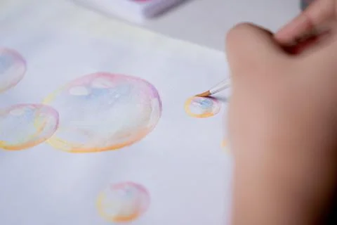 Hand coloring bubble drawing with colored watercolors in a sketchbook Stock Photos