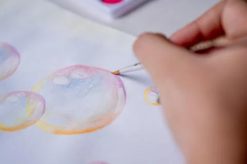 Hand coloring bubble drawing with colored watercolors in a sketchbook Stock Photos