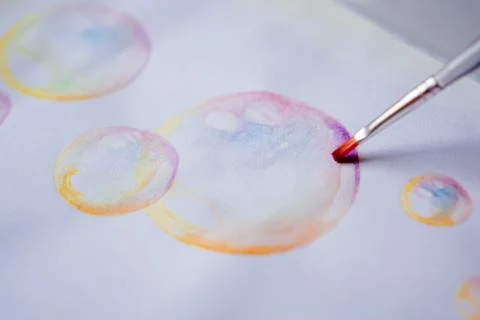 Hand coloring bubble drawing with colored watercolors in a sketchbook Stock Photos