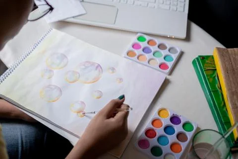 Hand coloring bubble drawing with colored watercolors in a sketchbook Stock Photos