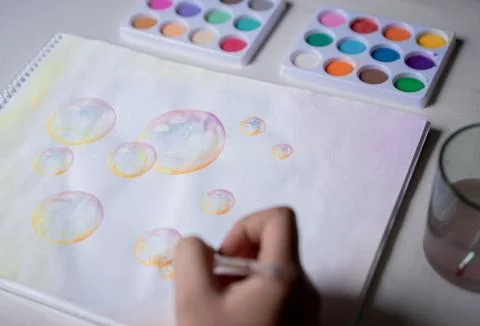 Hand coloring bubble drawing with colored watercolors in a sketchbook Foto stock