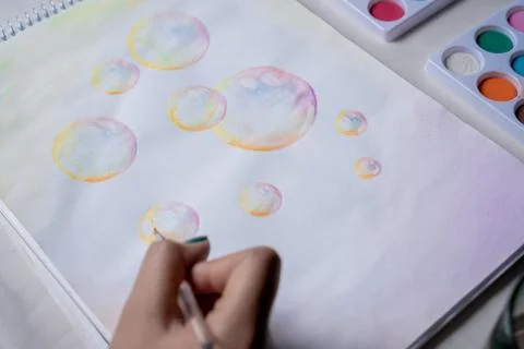 Hand coloring bubble drawing with colored watercolors in a sketchbook Stock-Fotos