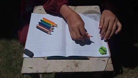 Hand coloring or drawing with pencils on a notebook with school supplies. Stock Footage 313728850