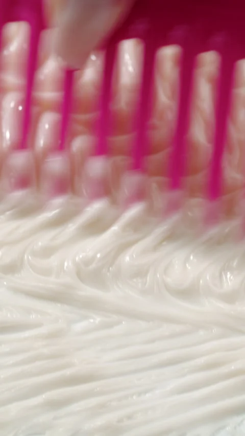 Hand combing thick cream with wide pink comb Stock Footage 311025437