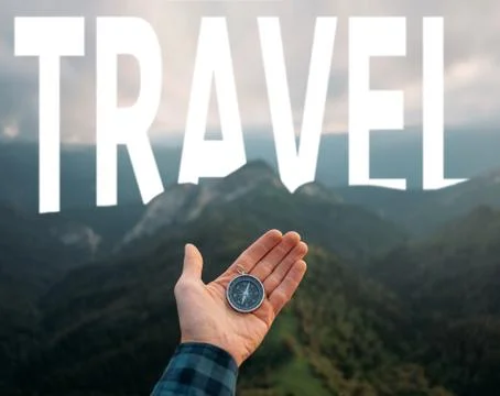 Hand with compass on background of mountains and word travel, pov. Stock Photos