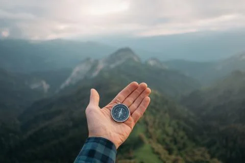 Hand with compass in the mountains. Stock Photos
