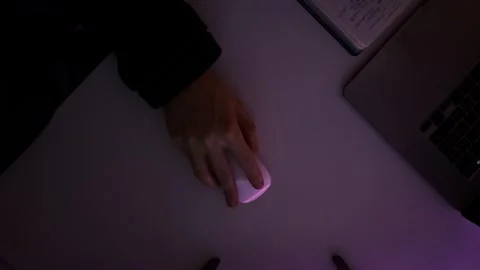 Hand with computer mouse top view at dark with vibe purple lightning Stock Footage 264404691