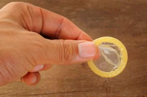 Hand with condom Stock Photos