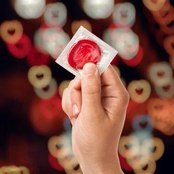 Hand with condom Stock Photos