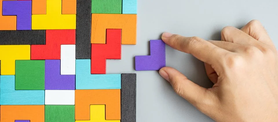 Hand connecting geometric shape block with colorful wood puzzle pieces. log.. Stock Photos