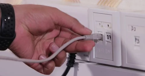 Hand connecting telephone connector to a network jack Stock Footage 146730702