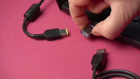 Hand connecting USB cable to laptop port, showcasing the progression of plugging Stock Footage 329475716