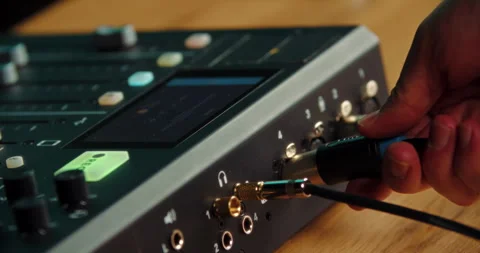 Hand connecting XLR audio cable to professional sound mixer Stock Footage 316247464