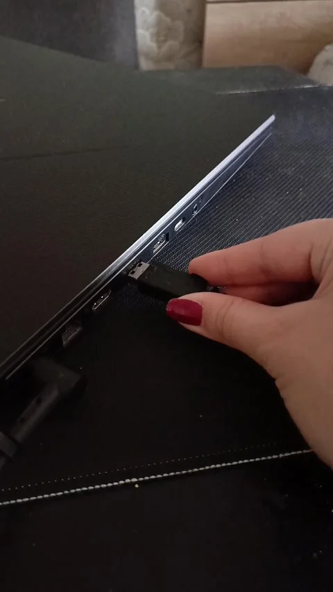 The hand connects the usb cable to the laptop. Connecting the Internet, mouse Stock Footage 319980590