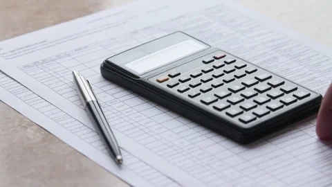 Hand considers on the calculator Stock Footage 85433356