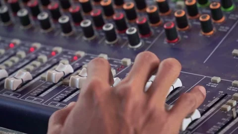 Hand controlling sound mixer panel, colorful knobs and LED level meters, audio Stock-Footage 344011371