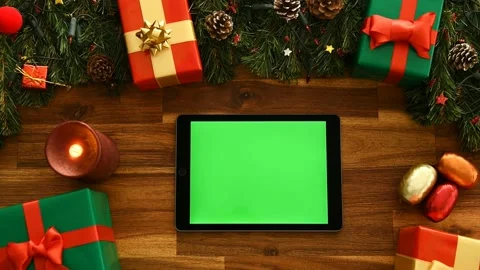 The hand controls the tablet. Decorations and gifts on the table. Use Device. 4K Stock Footage 220927980