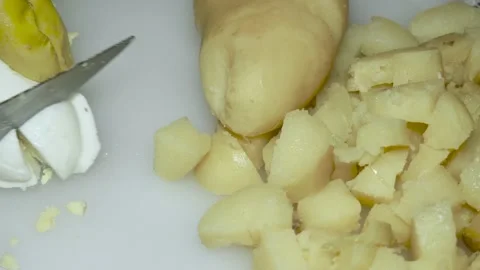 The hand of the cook cuts the boiled egg next to the boiled potatoes Vídeos de archivo 231199207