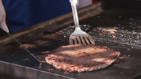 Hand of cook grilling meat for huge humburger. Stock Footage 79284881