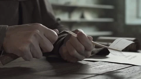 Hand of a copyist sharpening the end of a quill with a penknife, tracking shot Stock Footage 339631377