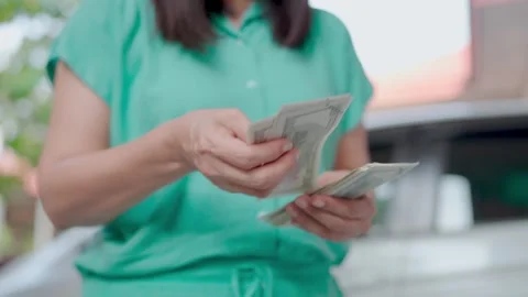 Hand counting US dollar bills or paying in cash on money background. Concepts  Stock Footage 265948223