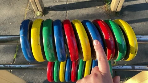 Hand counts colored rings on the playground. Stock Footage 194718246
