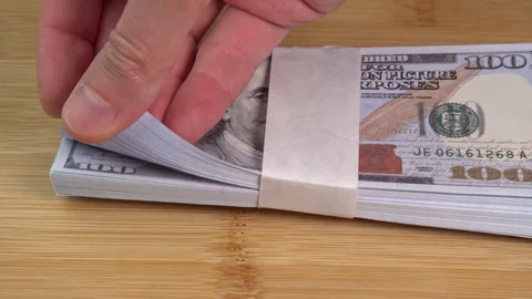 Hand counts stack of US dollars on the table. Counterfeiters check banknotes. Stock Footage 246519013