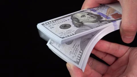 Hand counts stack of US dollars on the table. Counterfeiters check banknotes. Stock Footage 246519105