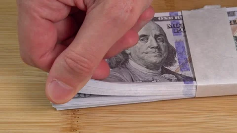 Hand counts stack of US dollars on the table. Counterfeiters check banknotes. Stock Footage 246519218