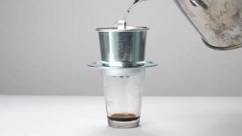 Hand Covering Vietnamese Phin Filter As Coffee Drips In Glass Video stock 331929342