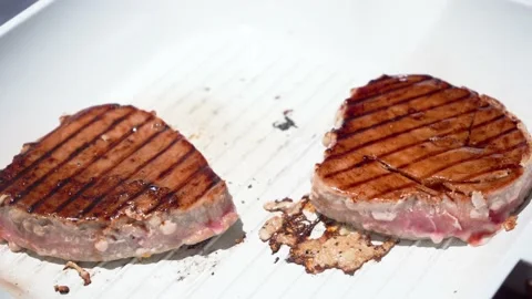Hand covers tuna steak in soy sauce silicone brush and sprinkle spices seasoning Stock Footage 157110473