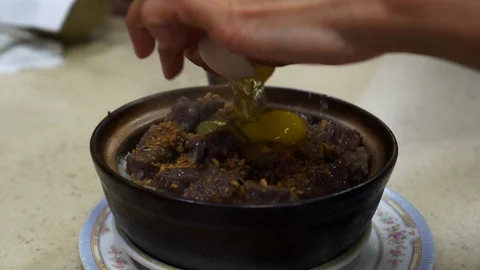 Hand crack egg in rice clay pot Hong Kong Cantonese style Chinese food Stock-Footage 126481006